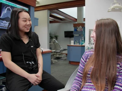 Dental team member talking with a relaxed patient in the treatment room