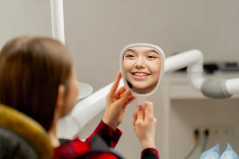 Patient checking her smile in a hand mirror