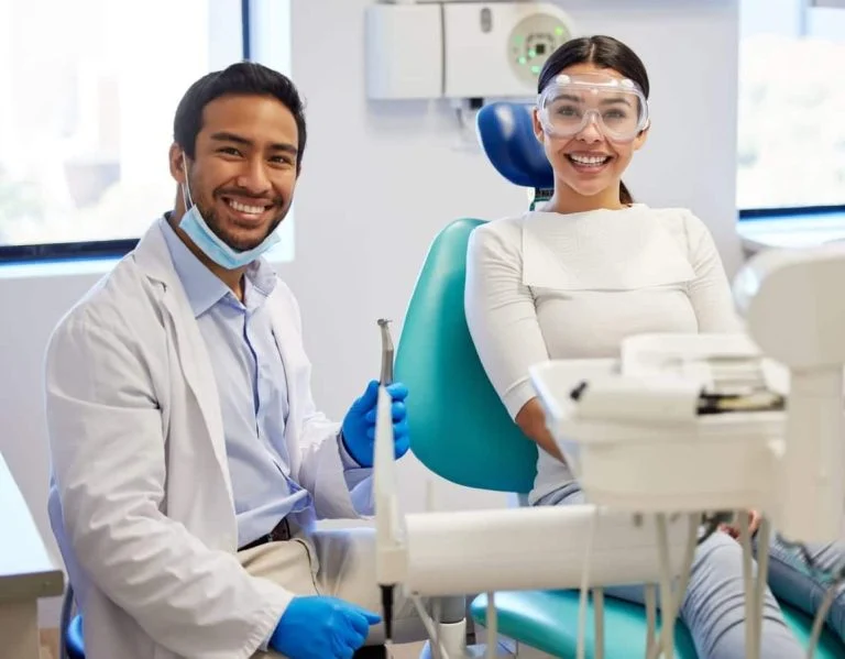 Smiling dentist with a patient in the dental chair